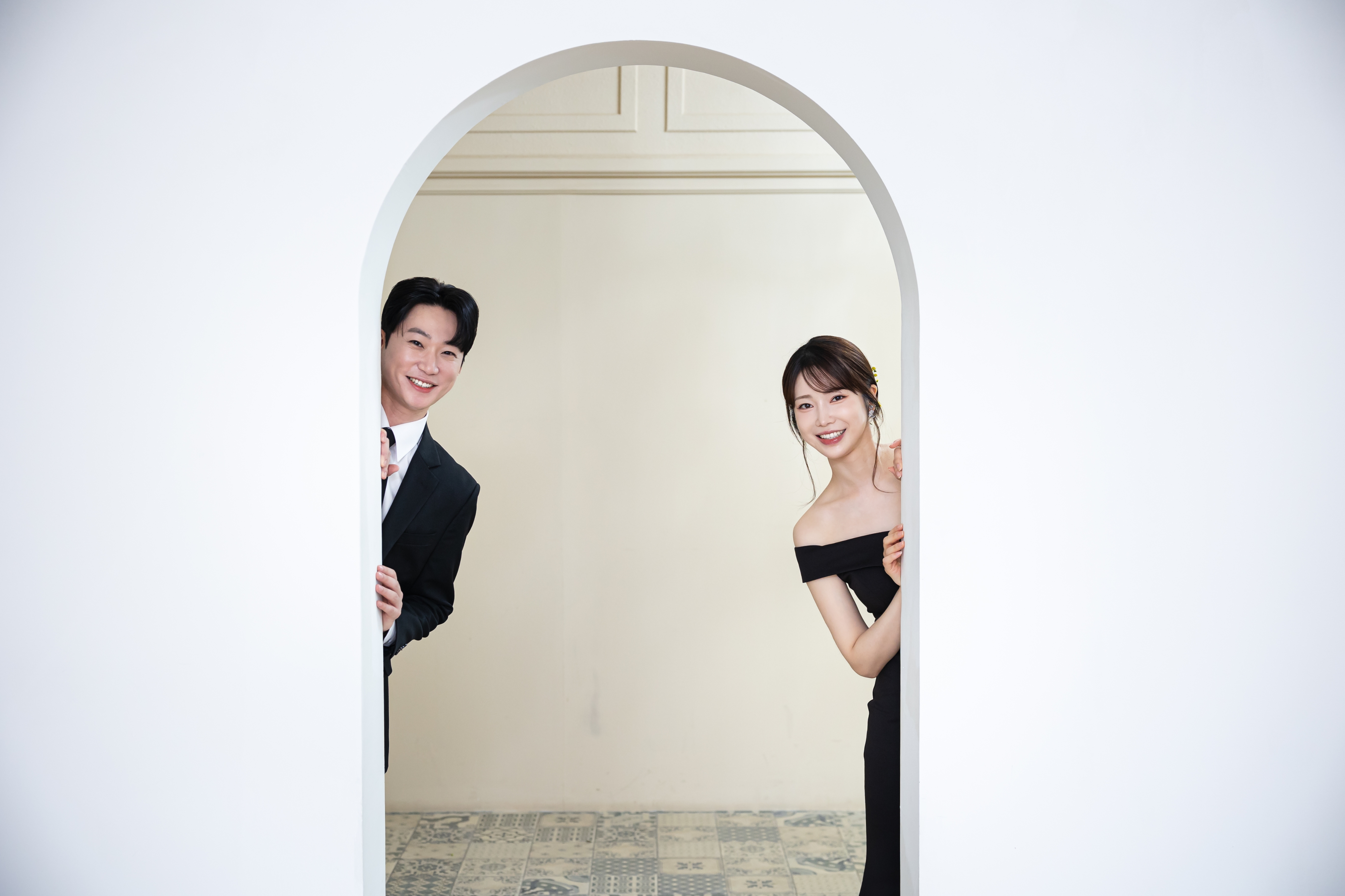 아치형 문 양쪽에서 얼굴을 내밀며 웃는 형욱과 은지